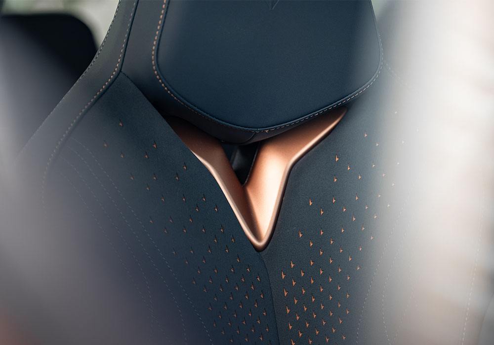 Close up detail shot of a leather headrest with copper accents in a sports car