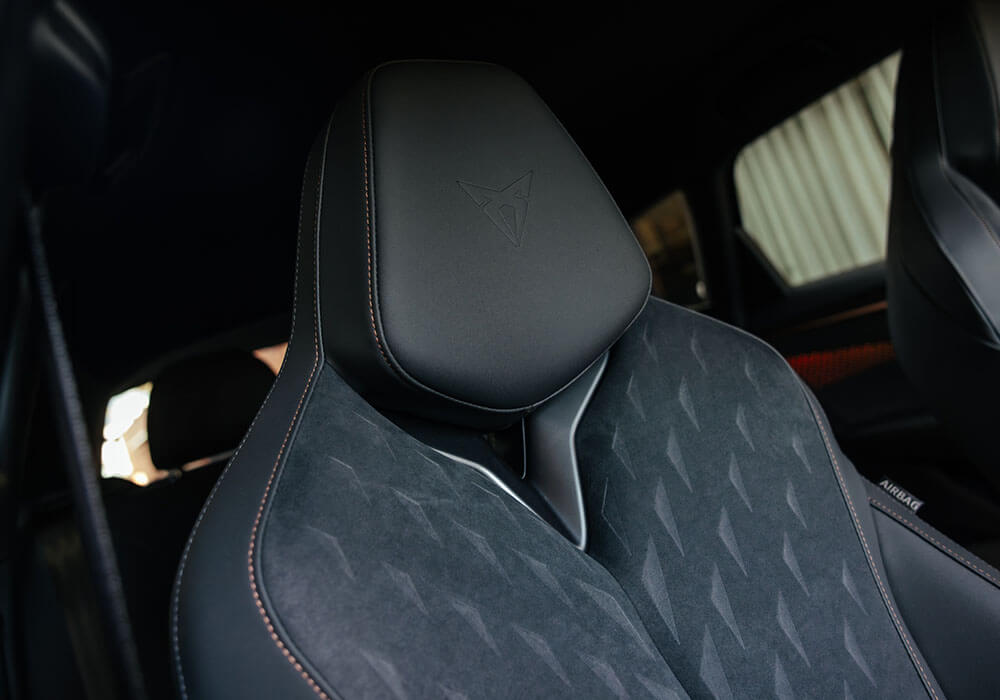 Close up view of a CUPRA emblem in a leather headrest