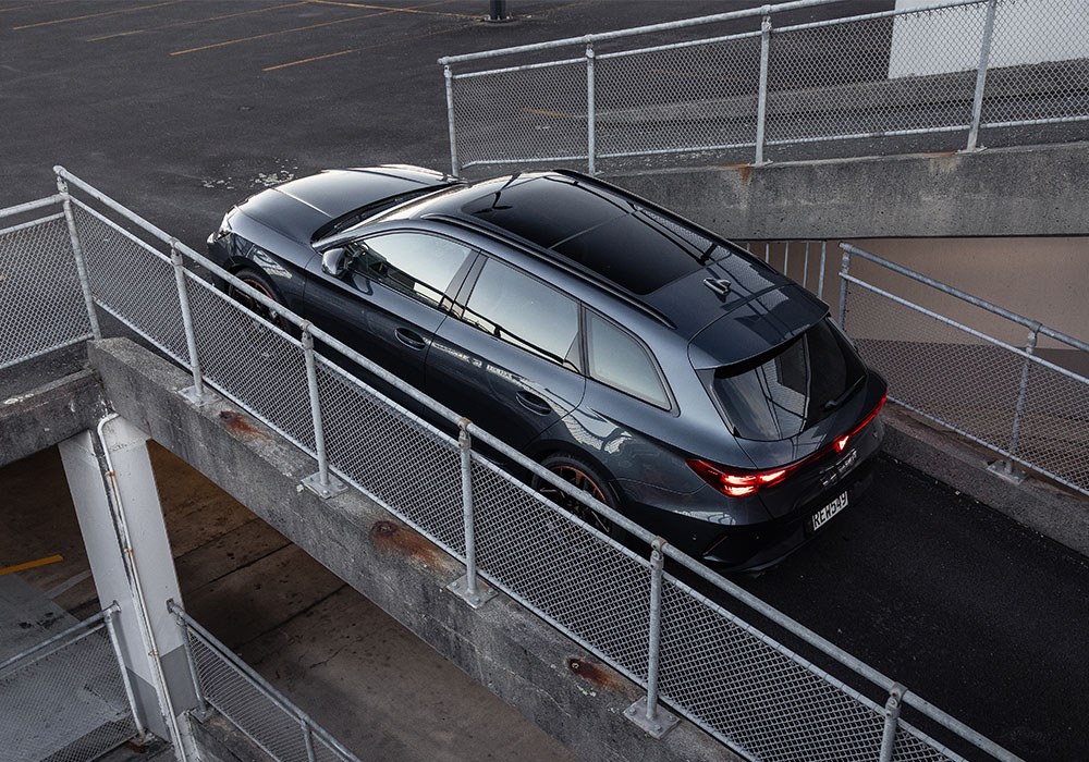high angle of a black station wagon driving up a ramp