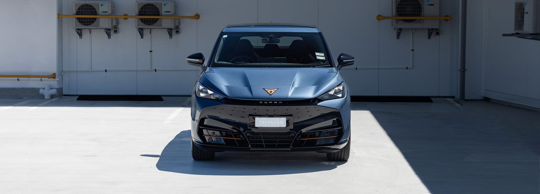 Front view of a blue CUPRA Tavascan EV parked